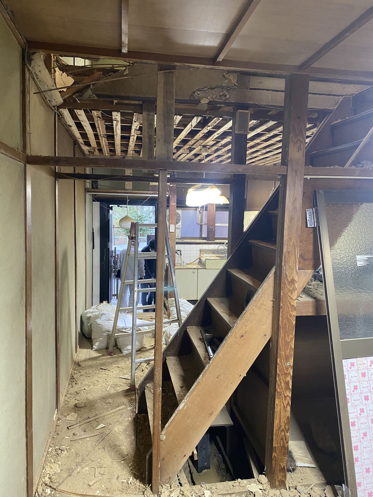 築古長屋の解体作業中。天井を剥がして階段まわりの構造があらわになった現場